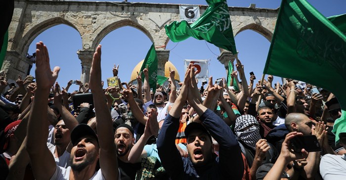 People hold Hamas flags as Palestinians gather after performing the last Friday of Ramadan to protest over the possible eviction of several Palestinian families from homes on land claimed by Jewish settlers in the Sheikh Jarrah neighbourhood, in Jerusalem's Old City, May 7, 2021. Reuters/Ammar Awad