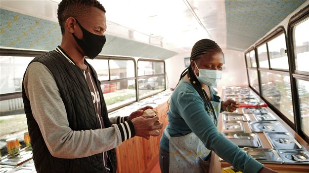 Sanele Msibi assists a customer inside the Skhaftin bus in Johannesburg. Thomson Reuters Foundation/Kim Harrisberg