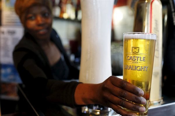 A bartender serves a beer produced by brewing company SAB Miller at a bar in Cape Town, September 16, 2015. Reuters/Mike Hutchings/File Photo