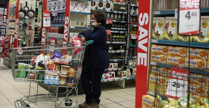 A shopper wearing a face mask waits her turn to pay for her grocery items, amid the spread of the coronavirus disease (Covid-19) at Mall of the south, in Johannesburg, South Africa, 17 June 2020. Source: Reuters/Siphiwe Sibeko