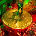 A small toy figure and representations of the virtual currency Bitcoin stand on a motherboard in this picture illustration taken May 20, 2021. Reuters/Dado Ruvic/Illustration