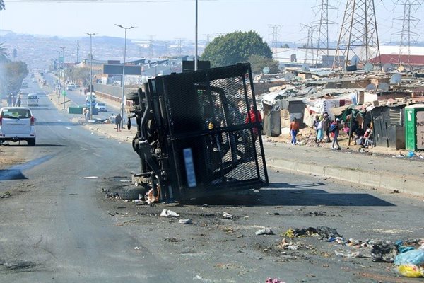 An overturned car blocks the road in Alexandra, Johannesburg.