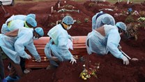 Funeral workers wearing personal protective equipment carry a casket during the burial of a Covid-19 victim, amid a nationwide coronavirus disease (Covid-19) lockdown, at the Olifantsvlei cemetery, south-west of Joburg, South Africa 6 January, 2021. Reuters/Siphiwe Sibeko