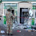 Members of the military look at damaged ATM machines outside a bank as the country deploys army to quell unrest linked to jailing of former President Jacob Zuma, in Soweto, South Africa, 13 July, 2021. Reuters/Siphiwe Sibeko