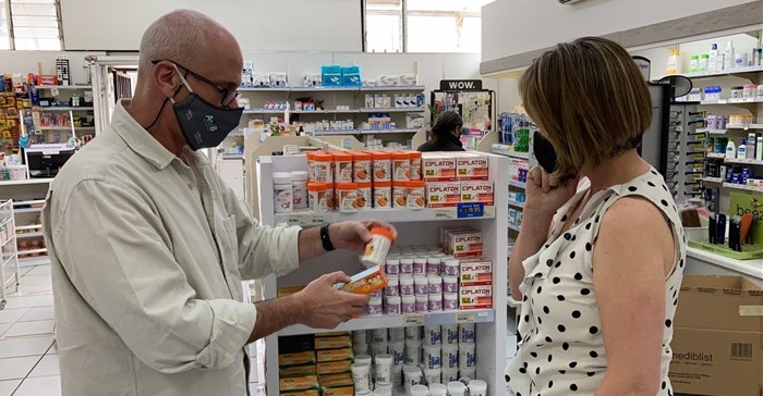 Saul Helman, a responsible pharmacist from Alpha Pharm Pharmacies assists a client (supplied by Alpha Pharm Pharmacies)