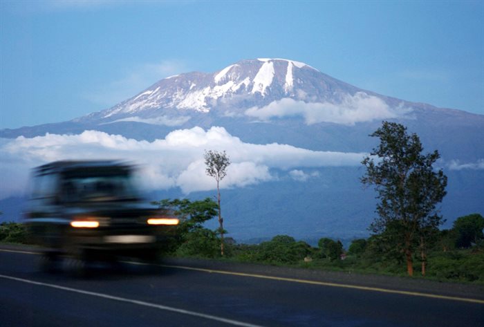 A vehicle drives past Mount Kilimanjaro in Tanzania's Hie district. Reuters/Katrina Manson