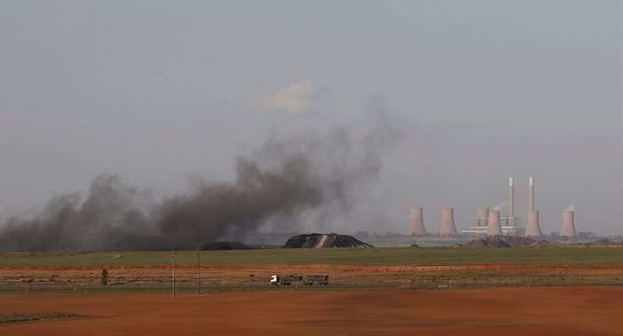 A truck drives past as coal dust rises in front of the Duvha coal-based power station owned by state power utility Eskom, in Emalahleni in Mpumalanga province, South Africa, 3 November 2021. | Source: Reuters/Siphiwe Sibeko