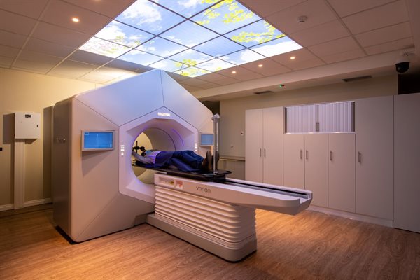 A staged photo with a model to demonstrate the how the Linac accommodates a patient.