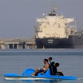 People enjoy the water while container ships park near the El Ain El Sokhna port before entering the Suez Canal, Egypt, 25 September 2020. Reuters/Amr Abdallah Dalsh