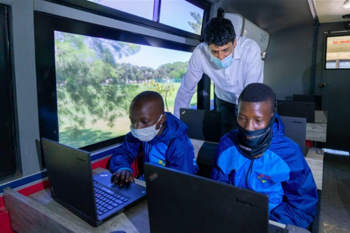 Investing in Education: Coronation CEO Anton Pillay spends time on the Atlas DigiBus, a state-of-the-art bus equipped with digital teaching resources, which will support five schools in Langa township in 2022.<p>Photo credit: Jay Caboz