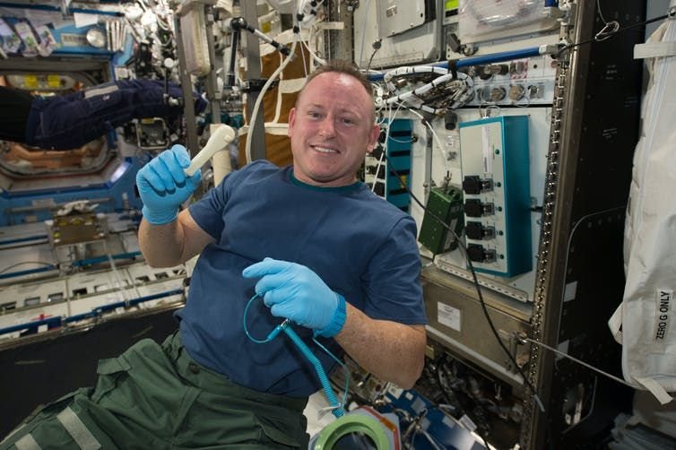 A NASA astronaut holds a ratchet created by the 3D printer on the International Space Station. ,