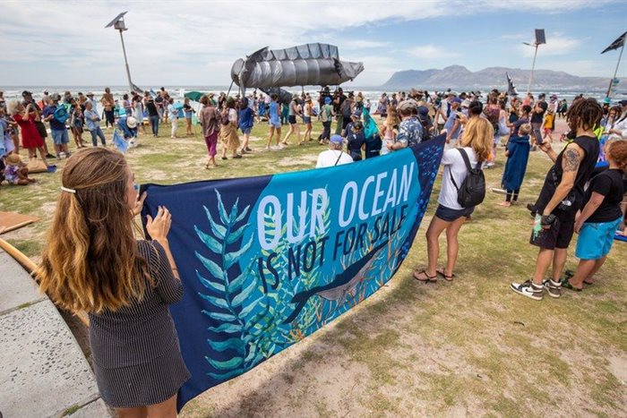 People protested against a seismic survey planned for the West Coast at Muizenberg beach on Sunday. An urgent court case will be held today in Cape Town. | Source: Ashraf Hendricks.