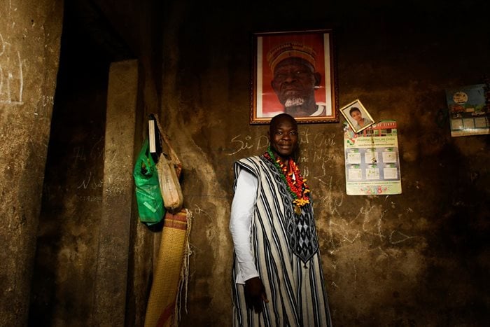 Francis Kere, an architect who won Pritzker Prize, poses for photograph in his house with his father's and his daughter's pictures in Gando, Burkina Faso. Reuters/Anne Mimault