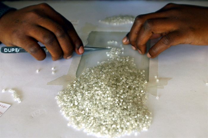A worker at the Botswana Diamond Valuing Company displays a rough diamond during the sorting process at the purpose-built centre in Gaborone. Source: Reuters