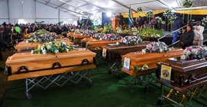 People gather near empty coffins ahead of a mass funeral for victims of an east coast tavern where bodies of youth were found which prompted nationwide grief, in the Eastern Cape province, in East London, South Africa, 6 July 2022. Reuters/Siphiwe Sibeko