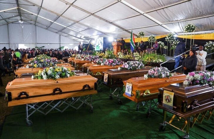 People gather near empty coffins ahead of a mass funeral for victims of an east coast tavern where bodies of youth were found which prompted nationwide grief, in the Eastern Cape province, in East London, South Africa, 6 July 2022. Reuters/Siphiwe Sibeko