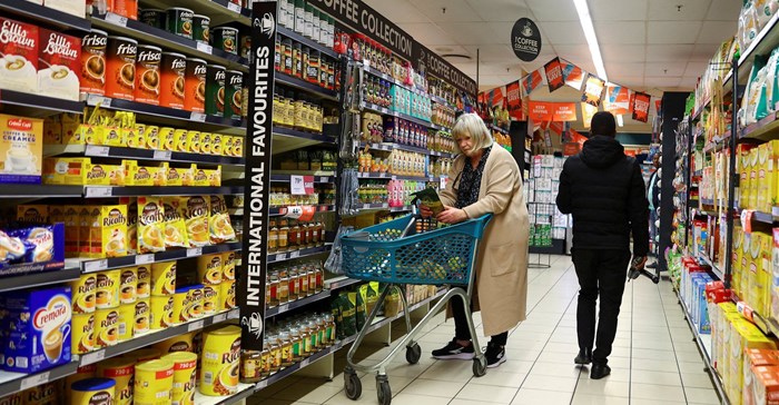 Source: Reuters. A woman uses a trolley as she shops at a grocery store in East London, in the Eastern Cape province.