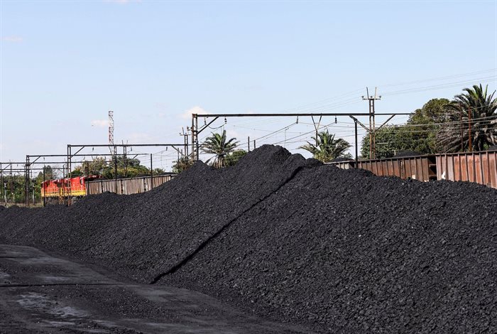 A Transnet Freight Rail train is seen next to tons of coal mined from the nearby Khanye Colliery mine, at the Bronkhorstspruit station around 90 kilometres north-east of Johannesburg. 2022. Reuters/Siphiwe Sibeko