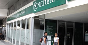 Source: Reuters. Customers look on outside Nedbank at the Mall of the South in Johannesburg.