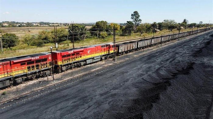 A Transnet freight rail train is seen next to tons of coal mined from the nearby Khanye Colliery mine, at the Bronkhorstspruit station. 2022. Source: Reuters/Siphiwe Sibeko