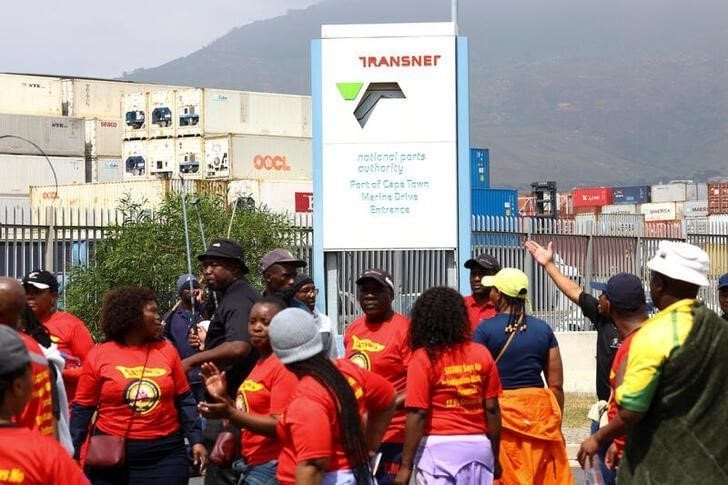 Workers at South Africa's state-owned logistics firm Transnet walk past ship containers as they continue on a nationwide strike outside the Port of Cape Town that could paralyse ports and freight rail services, amid talks to end a wage deadlock with the company, in Cape Town, South Africa, October 11, 2022. REUTERS/Esa Alexander