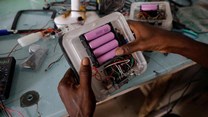 An employee inserts lithium-ion cells from old laptop battery packs into a solar lantern at the Quadloop recycling facility in Lagos, Nigeria. Source: Reuters/Temilade Adelaja