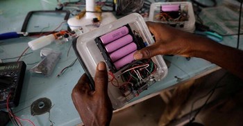 An employee inserts lithium-ion cells from old laptop battery packs into a solar lantern at the Quadloop recycling facility in Lagos, Nigeria. Source: Reuters/Temilade Adelaja