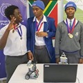 Dickson Madzivadondo, Pracahzel Kimbini and Elihle Zenzile with the robot they created. Photo: Supplied.