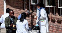 Source: Reuters. Zimbabwean medical workers sit outside Sally Mugabe Hospital during a strike by state doctors and nurses to press for higher pay, in Harare, Zimbabwe, June 20, 2022.