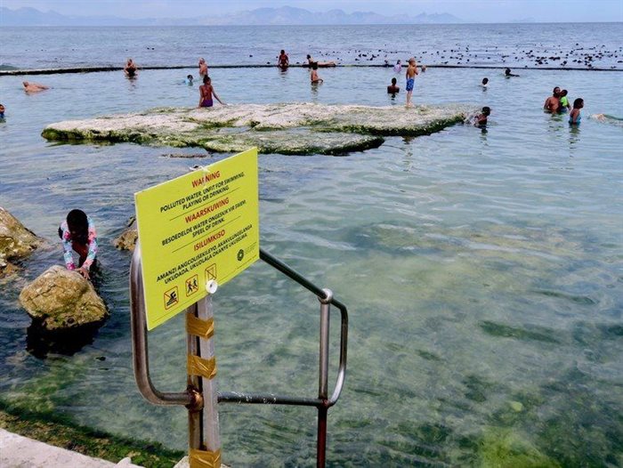 Visitors, including children, were swimming in Kalk Bay’s Dalebrook tidal pool on 11 January despite a warning sign posted by the City of Cape Town. Source: Steve Kretzmann/GroundUp