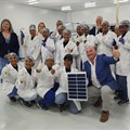 Supplied image: Alderman James Vos, Mayoral Committee Member for Economic Growth with employees of the company displaying an example of the solar panels manufactured.