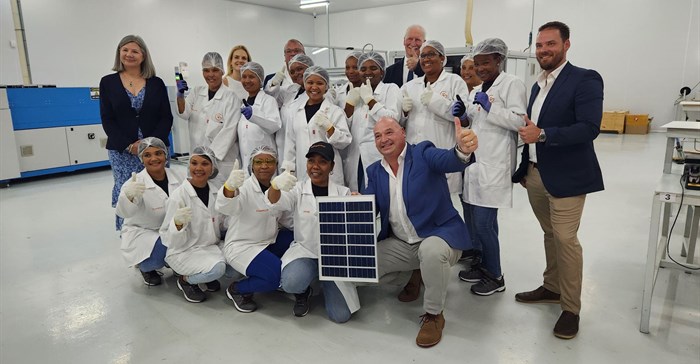 Supplied image: Alderman James Vos, Mayoral Committee Member for Economic Growth with employees of the company displaying an example of the solar panels manufactured.