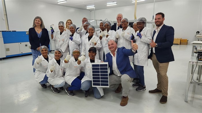 Alderman James Vos, Mayoral Committee Member for Economic Growth with employees of the company displaying an example of the solar panels manufactured.