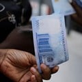 Source: Reuters. A person holds a new 1000 Naira note as the Central Bank of Nigeria releases the notes to the public through the banks in Abuja, Nigeria.