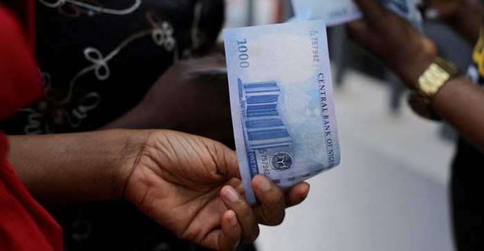 Source: Reuters. A person holds a new 1000 Naira note as the Central Bank of Nigeria releases the notes to the public through the banks in Abuja, Nigeria.