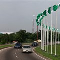 Cars drive past Nigerian national flags in Abuja, Nigeria 12 June 2021. Reuters/Afolabi Sotunde