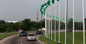 Cars drive past Nigerian national flags in Abuja, Nigeria 12 June 2021. Reuters/Afolabi Sotunde
