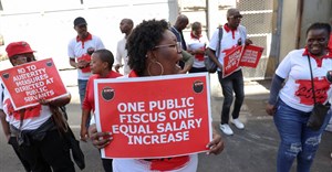 Members of the South African public sector union, National Education, Health and Allied Workers' Union (Nehawu) hold placards outside the Home Affairs office during a protest over wage disputes and other work issues in Cape Town, South Africa, 13 March 2023. Reuters/Esa Alexander