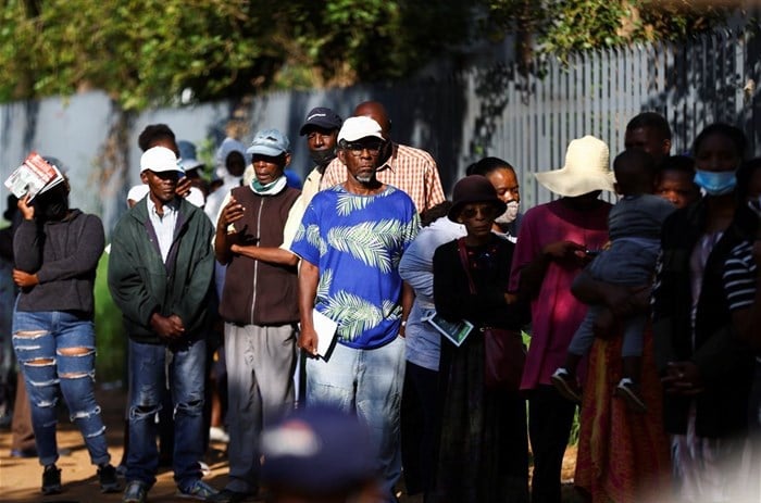 Social grant recipients stand in a queue outside a post office, as joblessness takes its toll in Meadowlands, a suburb of Soweto, South Africa, 24 February 2022. Reuters/Siphiwe Sibeko