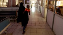 Source: Reuters. A woman walks with her child in the paediatric emergency unit at the Edward Francis Small teaching hospital in Banjul, Gambia, November 4, 2022.