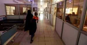 Source: Reuters. A woman walks with her child in the paediatric emergency unit at the Edward Francis Small teaching hospital in Banjul, Gambia, November 4, 2022.