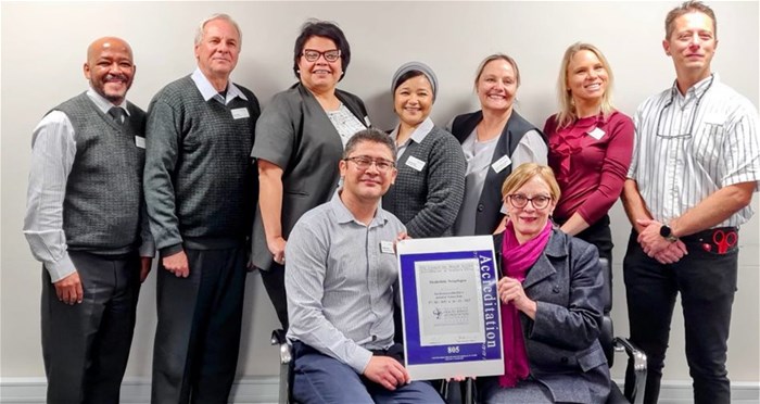 Marquin Crotz (left), general hospital manager of Mediclinic Vergelegen receives the Cohsasa accreditation certificate from CEO of Cohsasa, Jacqui Stewart. Photographed with them in the Mediclinic Vergelegen boardroom are members of the senior management of the hospital.
