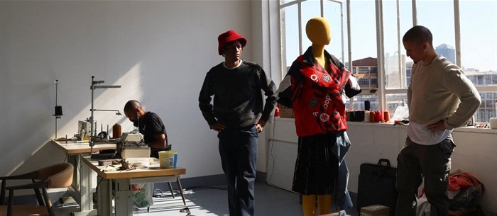 File photo: South African aspiring designers Khumo Morojele and Klein Muis look at one of their designs made from second hand clothing imported from the West and sold in bales in markets known as Dunusa, in Johannesburg South Africa, 3 July 2023.Reuters/Siphiwe Sibeko/File Photo