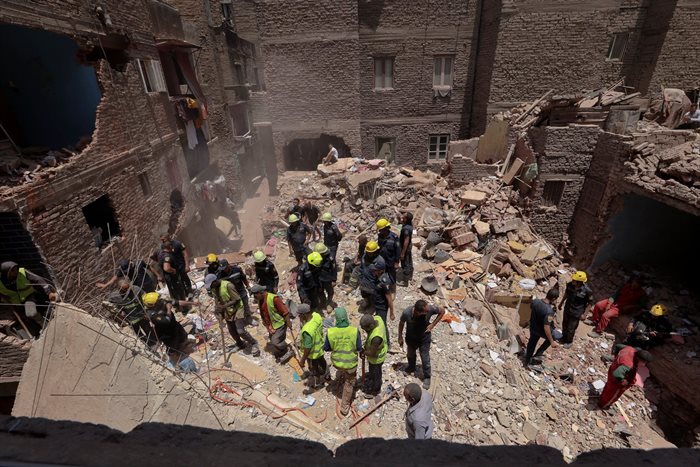 Egyptian emergency and rescue personnel search for survivors in the rubble of a five-story apartment building that collapsed, leaving several people dead, according to authorities, in Hadaeq al-Qubbah neighborhood, in Cairo, Egypt, 17 July 2023. Source: Reuters/Mohamed Abd El Ghany