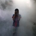 Source: Reuters.A boy covers his face from smoke as a health worker fumigates against mosquitoes in a residential area, as Sri Lanka tries to curb dengue fever across the island in Colombo, Sri Lanka 12 July, 2023.