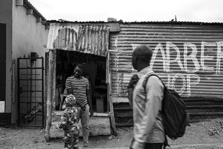 Masiphumelele resident Finiyas standing in front of his barbershop. His business is shaving hair and sewing clothes that need repair. Photo: Chelsea Mahlangu/  Instagram account published with permission