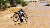 A man carries his bicycle over a flooded area in Muloza on the border with Mozambique after the tropical Cyclone Freddy, around 100km outside Blantyre, Malawi, 18 March 2023. Reuters/Esa Alexander