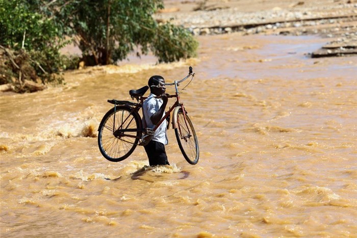 A man carries his bicycle over a flooded area in Muloza on the border with Mozambique after the tropical Cyclone Freddy, around 100 km outside Blantyre, Malawi, 18 March 2023. Reuters/Esa Alexander