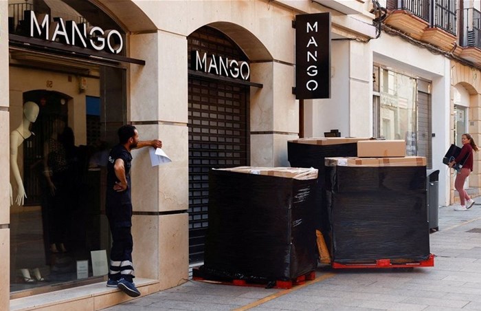 A delivery worker waits for the opening of a store of Spanish fashion chain Mango to deliver boxes with clothes, in Ronda, Spain. Source: Reuters/Jon Nazca