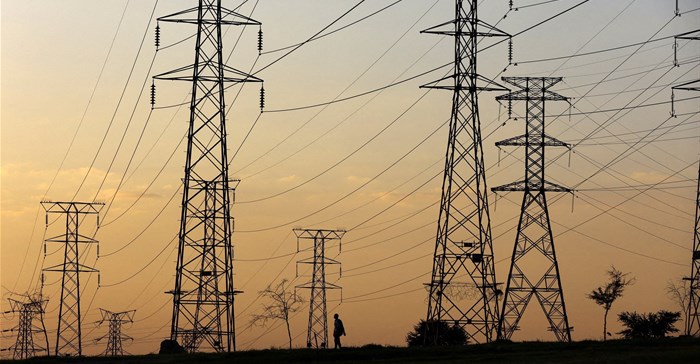 A man walks beneath electricity pylons during frequent power outages from South African utility Eskom, caused by its ageing coal-fired plants, in Orlando, Soweto. Source: Reuters/Siphiwe Sibeko